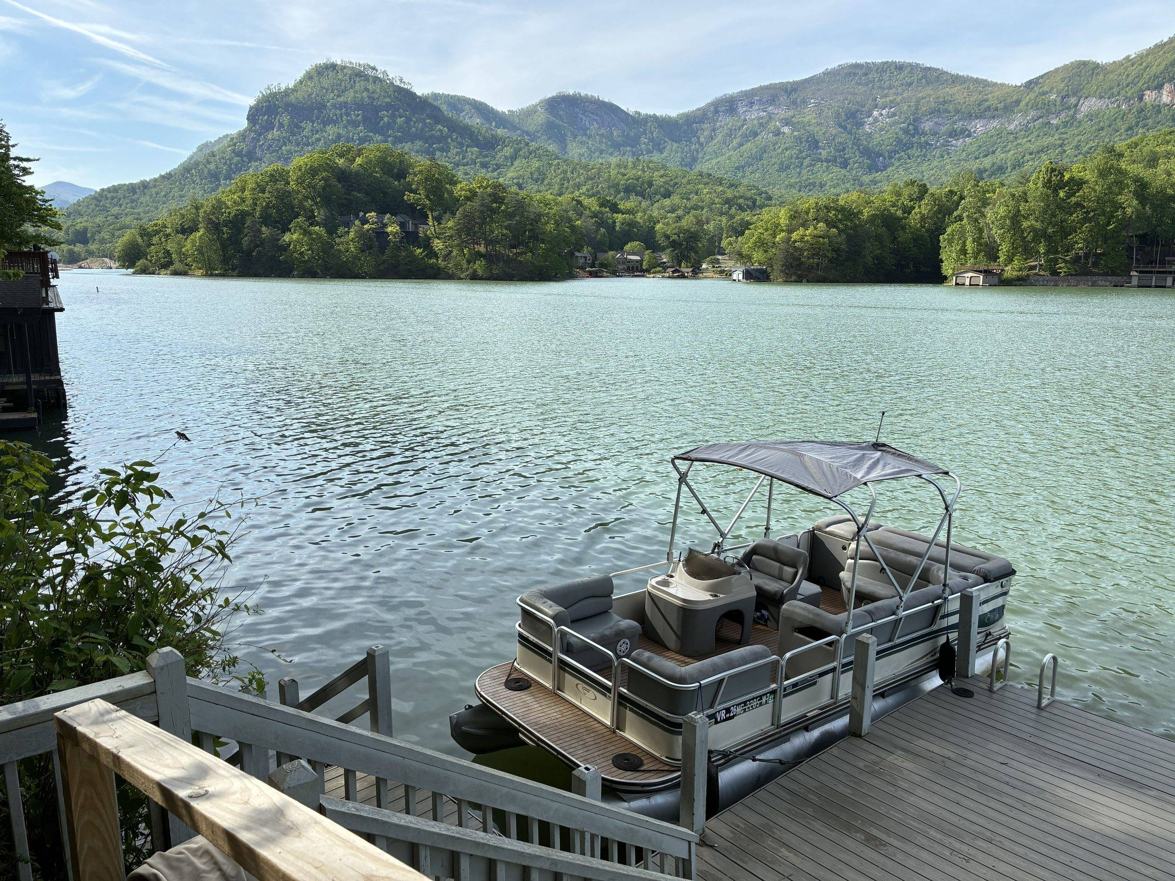 Pontoon boat docked on Lake Lure with the Rumbling Bald mountain ridge in the background
